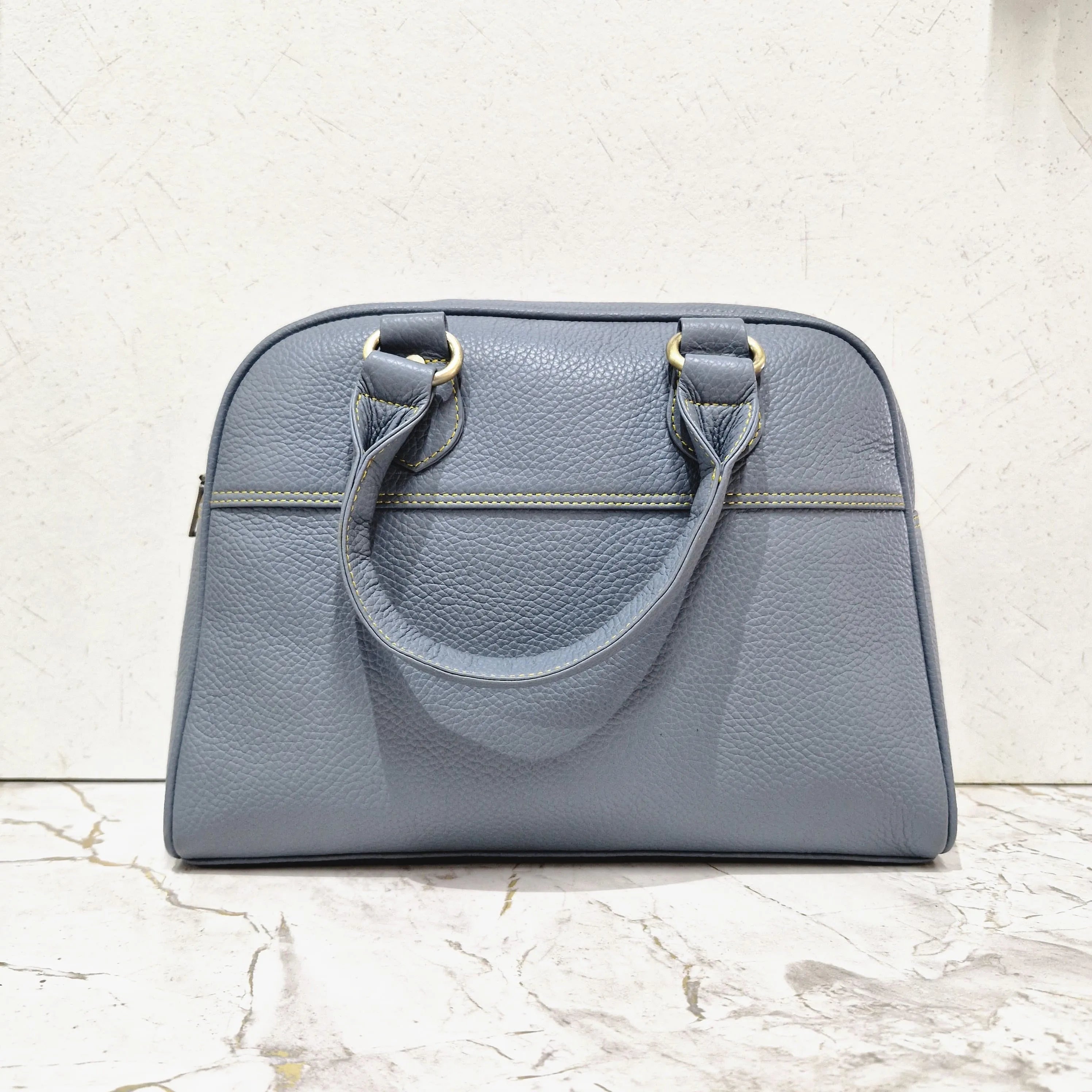 Blue pebbled genuine leather mini tote designer handbag with contrast yellow stitching and gold-tone hardware.