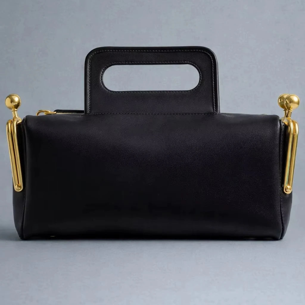 Black retro pillow handbag, designer PU leather shoulder bag with gold metal side clasps and integrated top handle.