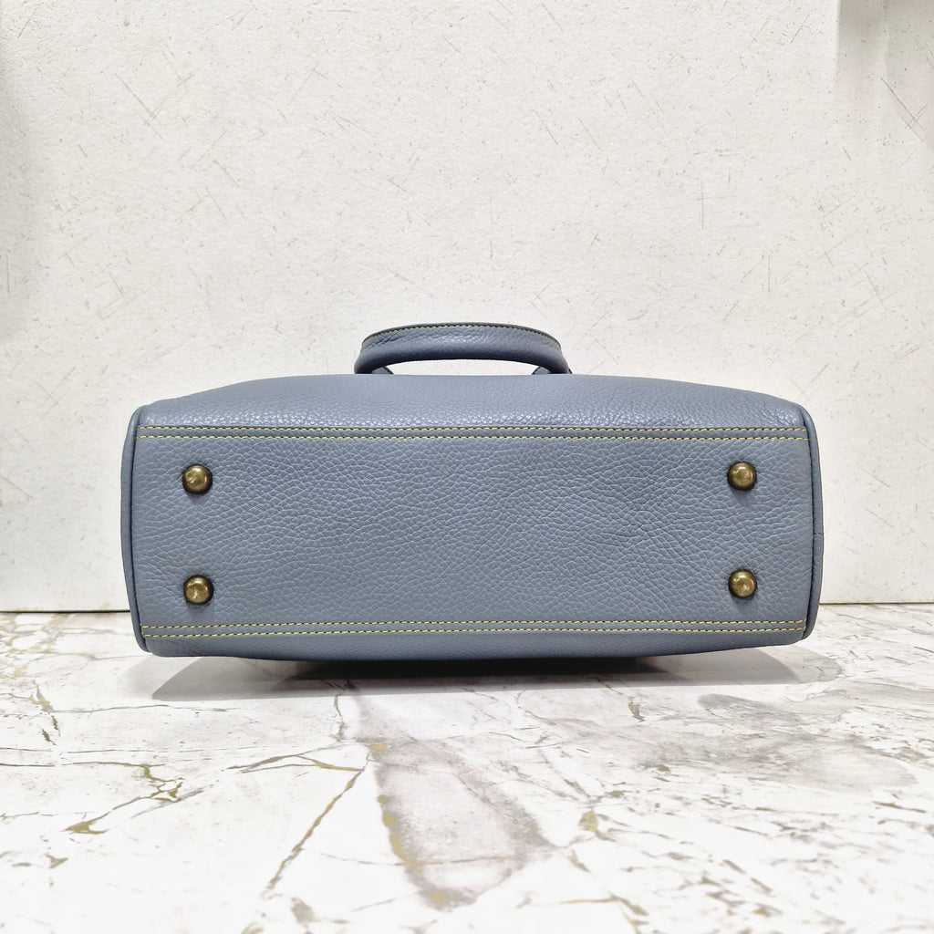 Blue pebbled genuine leather designer mini tote bag with gold metal feet and yellow contrast stitching.