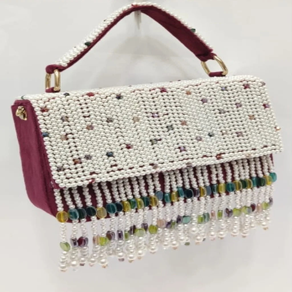Maroon designer clutch with white pearl embroidery, crystal bead fringe, and top handle for weddings and parties.