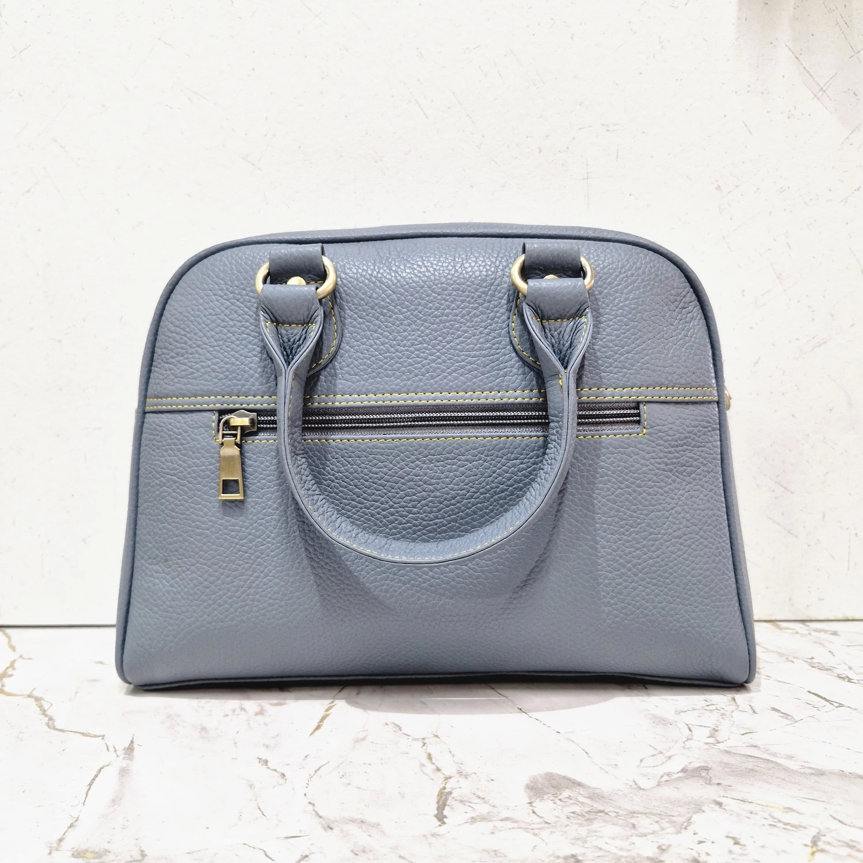 Blue pebble-grain genuine leather designer mini tote bag with gold-tone hardware and zippered exterior pocket.