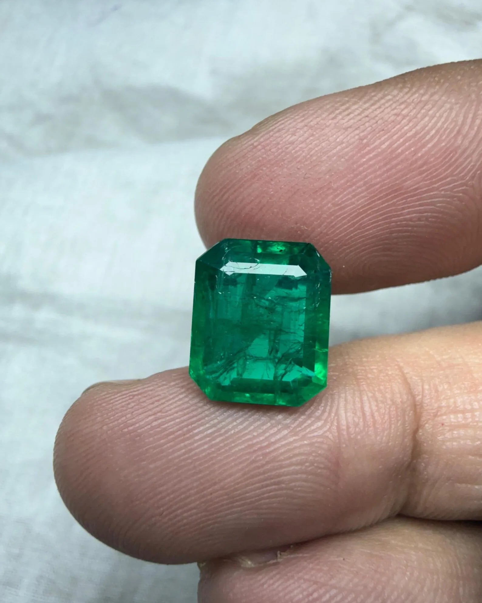 Green emerald-cut octagon gemstone shown front view with prominent step facets