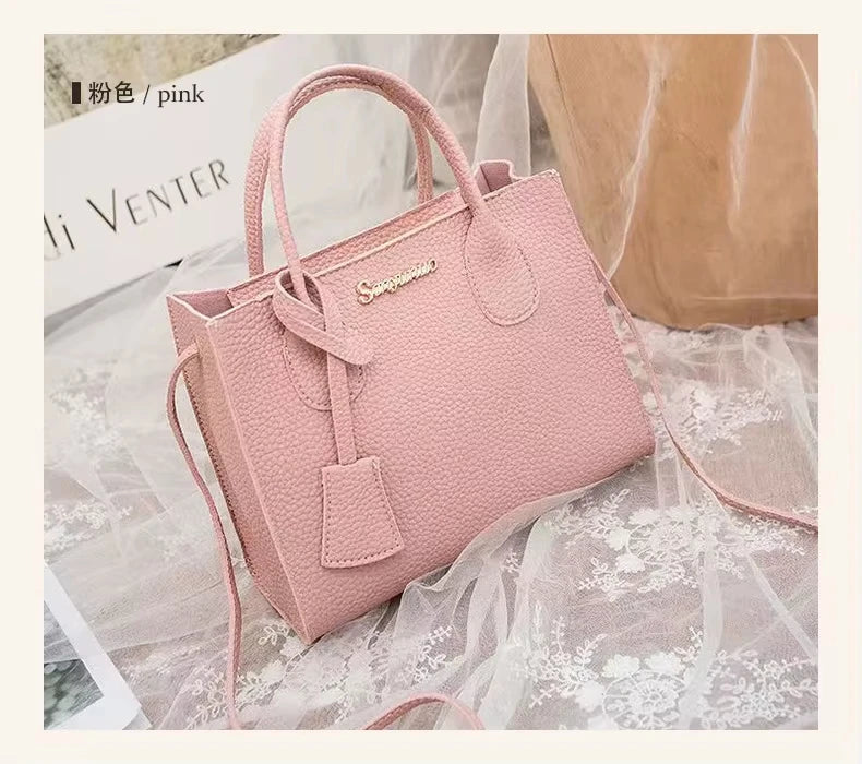Pink textured PU leather designer handbag with shoulder strap, gold logo, and minimalist structured tote style.
