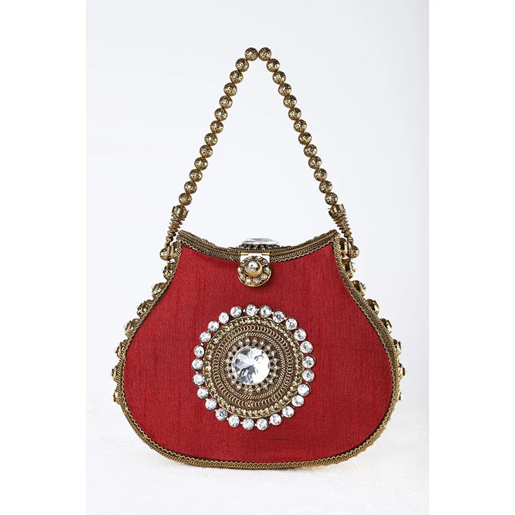 Red silk designer clutch with gold metal bead handle, crystal center medallion, and kiss lock closure.