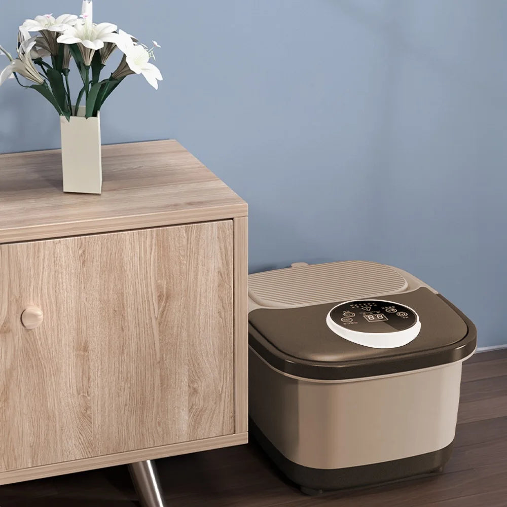 Automatic foot spa bath with a beige base and brown lid, featuring a digital control panel, placed on a wooden floor.