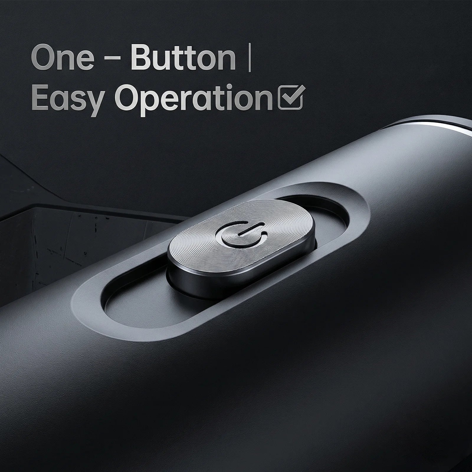 Close-up of a matte black portable coffee maker showing the textured metal power button and one-button operation.