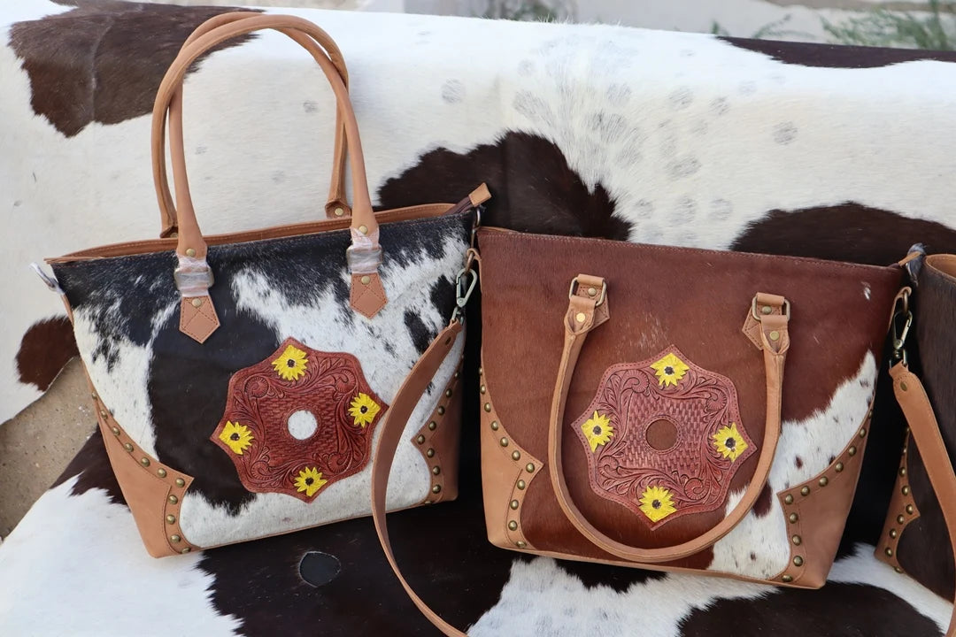 Western cowhide leather tote bags with floral tooling, yellow sunflower accents, zipper closure, and dual straps.