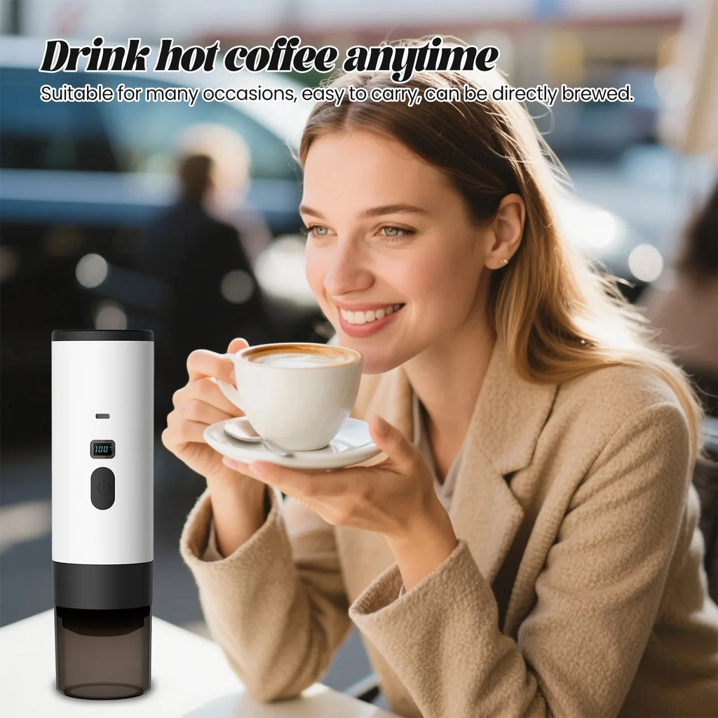 Portable white electric coffee maker with digital temperature display next to a woman drinking coffee at a table.