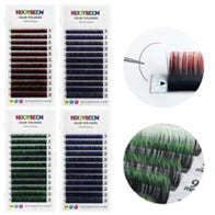 Colored eyelash extensions in red, purple, green, and blue on adhesive strips for professional makeup application.