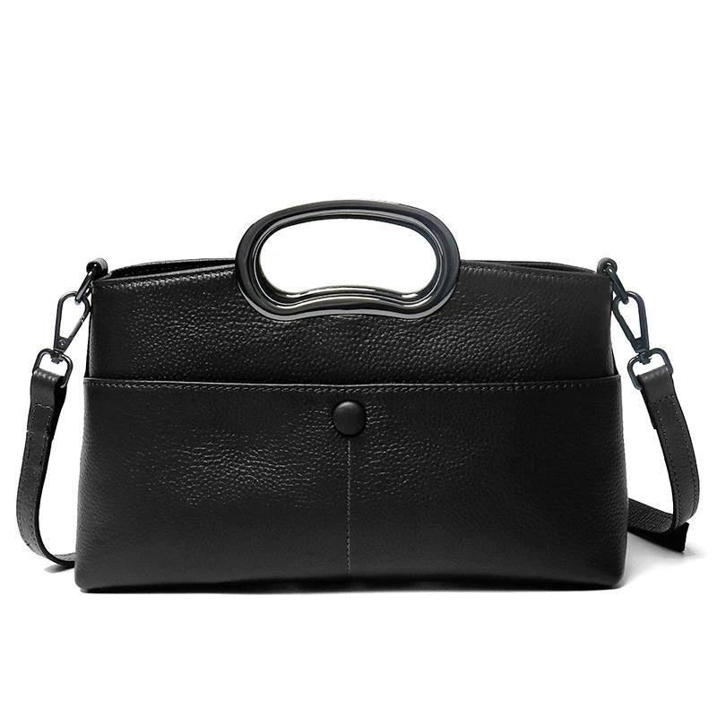 Black pebble PU leather designer handbag with a metallic cutout handle, button closure, and removable crossbody strap.
