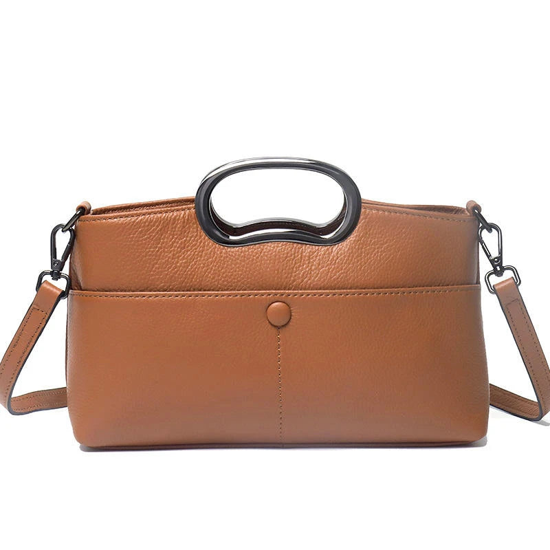 Tan PU leather designer handbag with a metallic cutout handle, shoulder strap, and front snap pocket.
