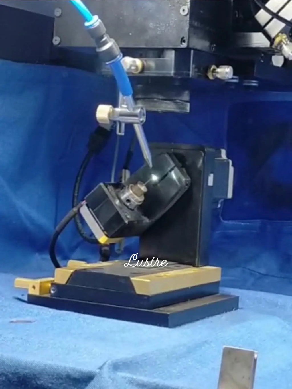 Jewelry polishing or cutting machine on a workbench with blue protective covering