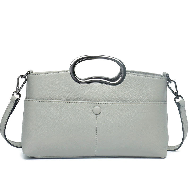 Light gray PU leather designer handbag with a metallic oval top handle, detachable strap, and minimalist front pocket.