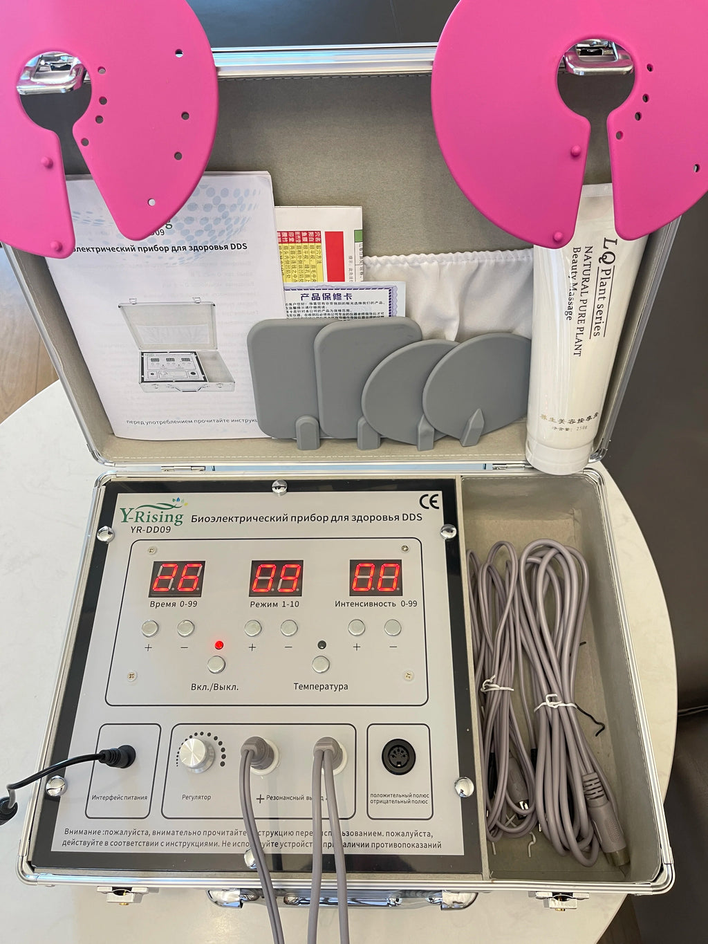 DDS bioelectrical body therapy massager kit with digital control panel, pink massage pads, and conducting gel in case.