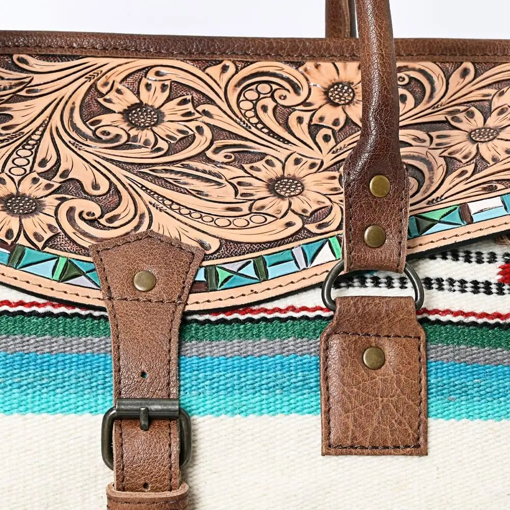 Handwoven western tooled leather duffel trunk with floral pattern, turquoise inlay accents, and colorful textile base.