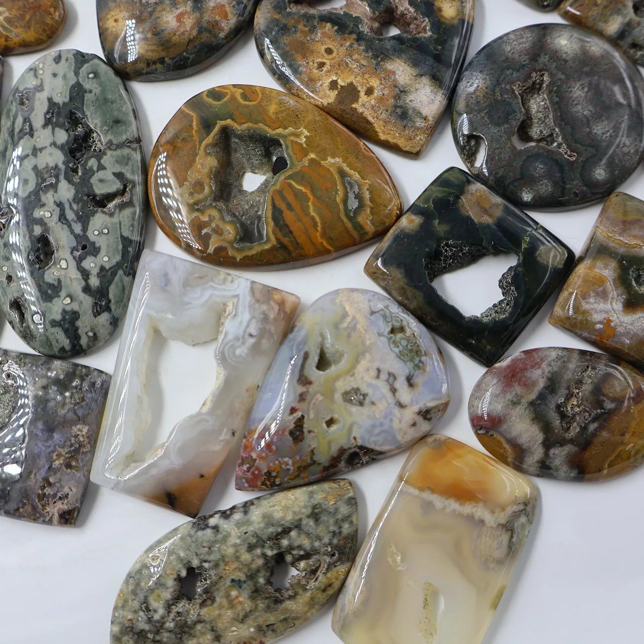 Assorted ocean jasper druzy cabochons, including oval, teardrop, and rectangle shapes
