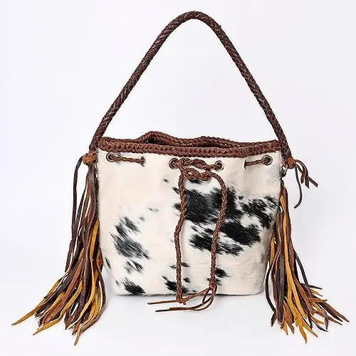 Vintage cowhide leather bucket bag with braided handle, fringe tassels, and drawstring closure. Brown and white print.