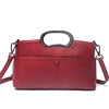 Luxury red PU leather designer handbag with top handle, detachable shoulder strap, and minimalist front pocket detail.