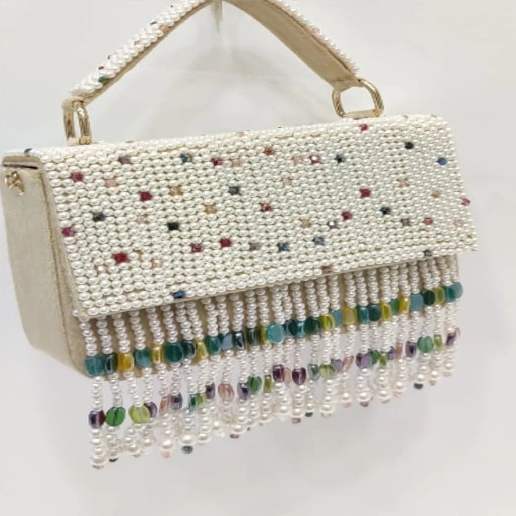 Luxury cream pearl-beaded evening handbag with colorful crystal fringe tassel, top handle, and elegant designer style.