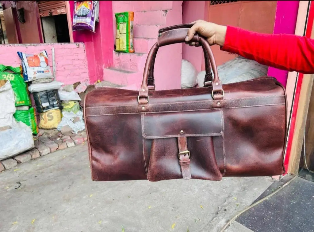 Large brown full grain leather gym trunk with a sturdy carry handle, front pocket, and adjustable buckle closure.
