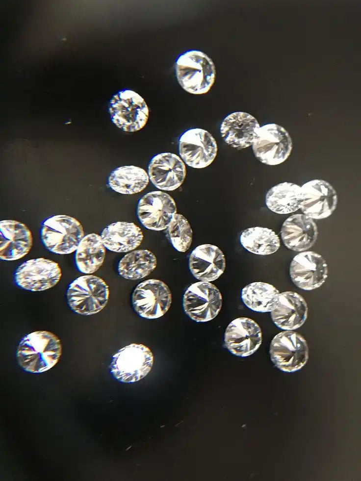 Loose round white diamonds, assorted sizes arranged in a scattered pattern