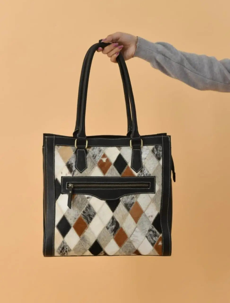 Stylish full-grain leather handbag with a geometric diamond pattern in brown, black, and white, featuring zip closure.