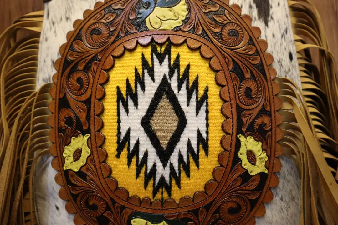 Handmade genuine leather crossbody trunk with tooled floral design, yellow woven pattern, and fringe detail.