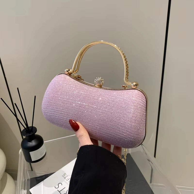 Luxury pink glitter evening clutch bag with gold crystal-embellished handle and clasp for weddings and parties.