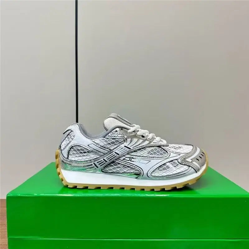 Luxury silver leather men's sneakers featuring a mesh panel design, white laces, and a rugged gum rubber outsole.