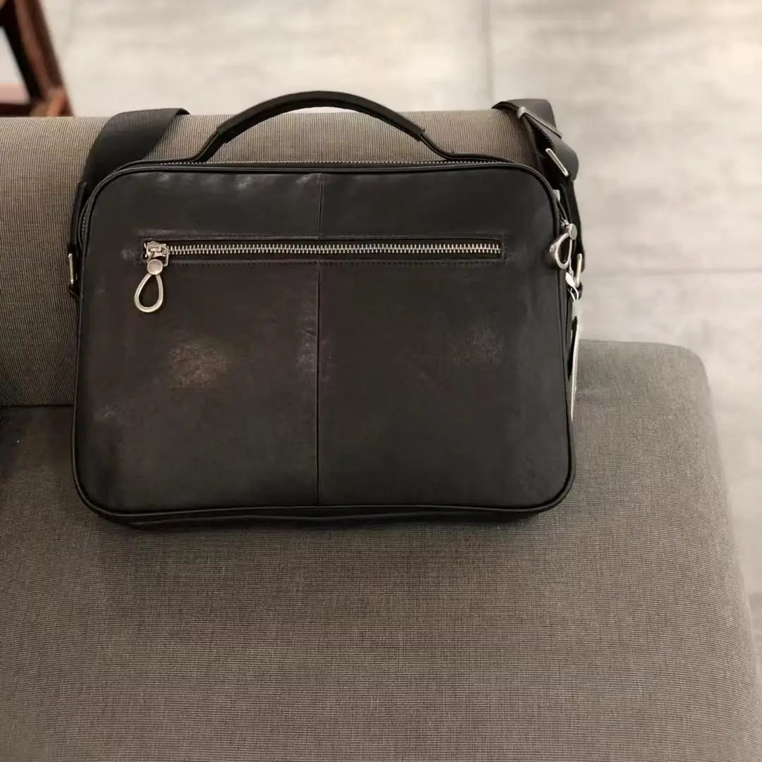 Black vintage cowhide leather messenger bag with horizontal zipper pocket, top handle, and adjustable shoulder strap.