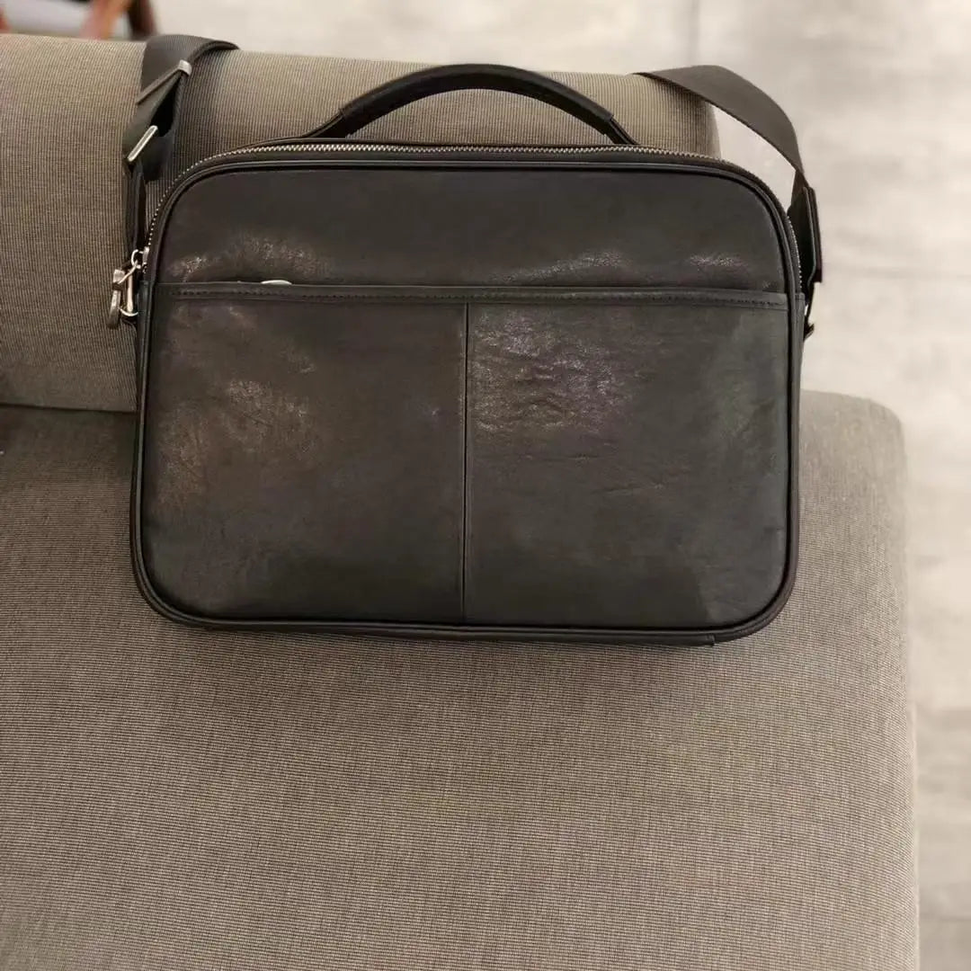 Vintage black cowhide leather horizontal messenger bag with top handle and crossbody strap for business daily carry.