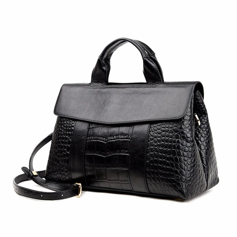 Black genuine leather designer crossbody bag with crocodile-textured panels and a structured top handle.