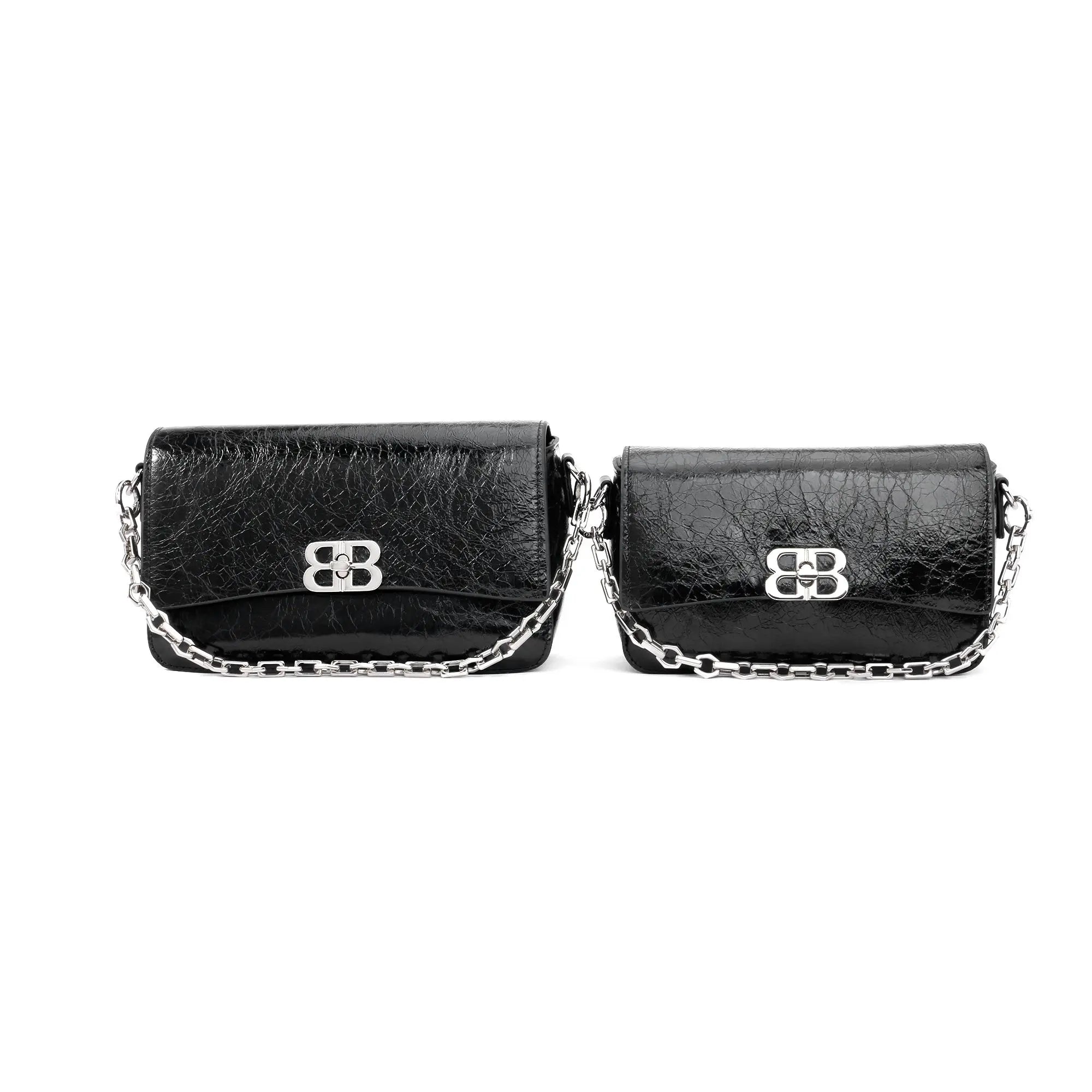 Two black crinkled leather designer clutch bags with silver chain straps and metallic clasp closures.