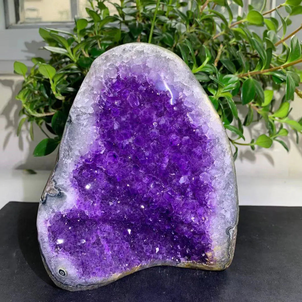 Large amethyst geode crystal cluster with glittering purple crystal surface