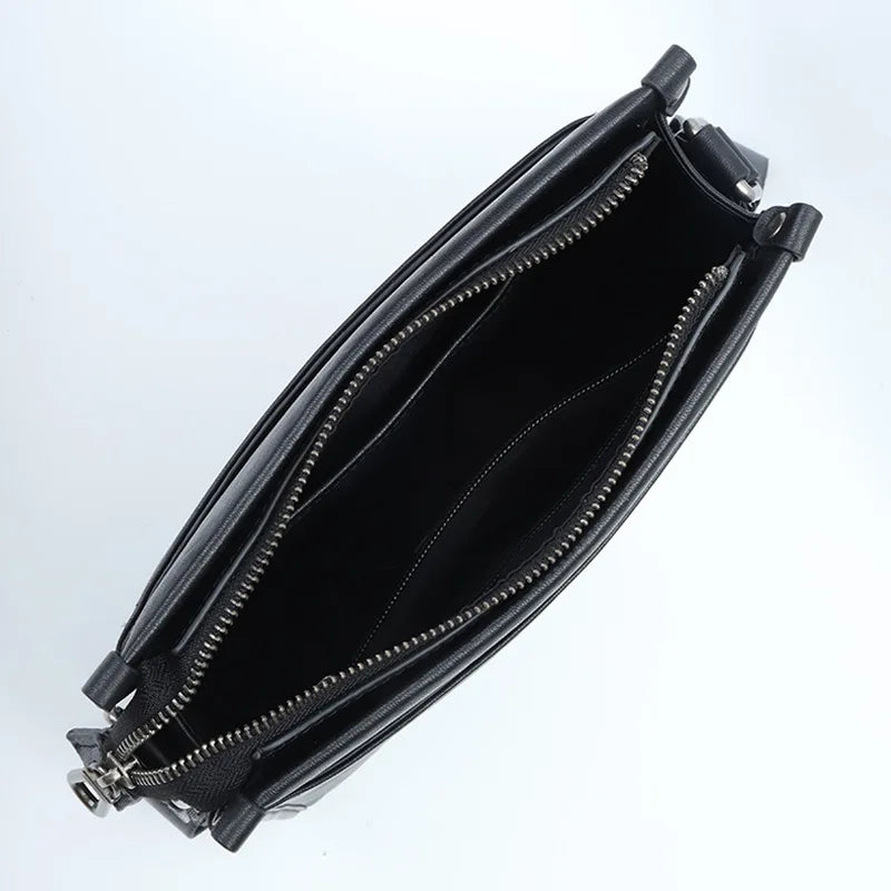 Black genuine leather designer crossbody bag with zippered main compartment and spacious interior organization.