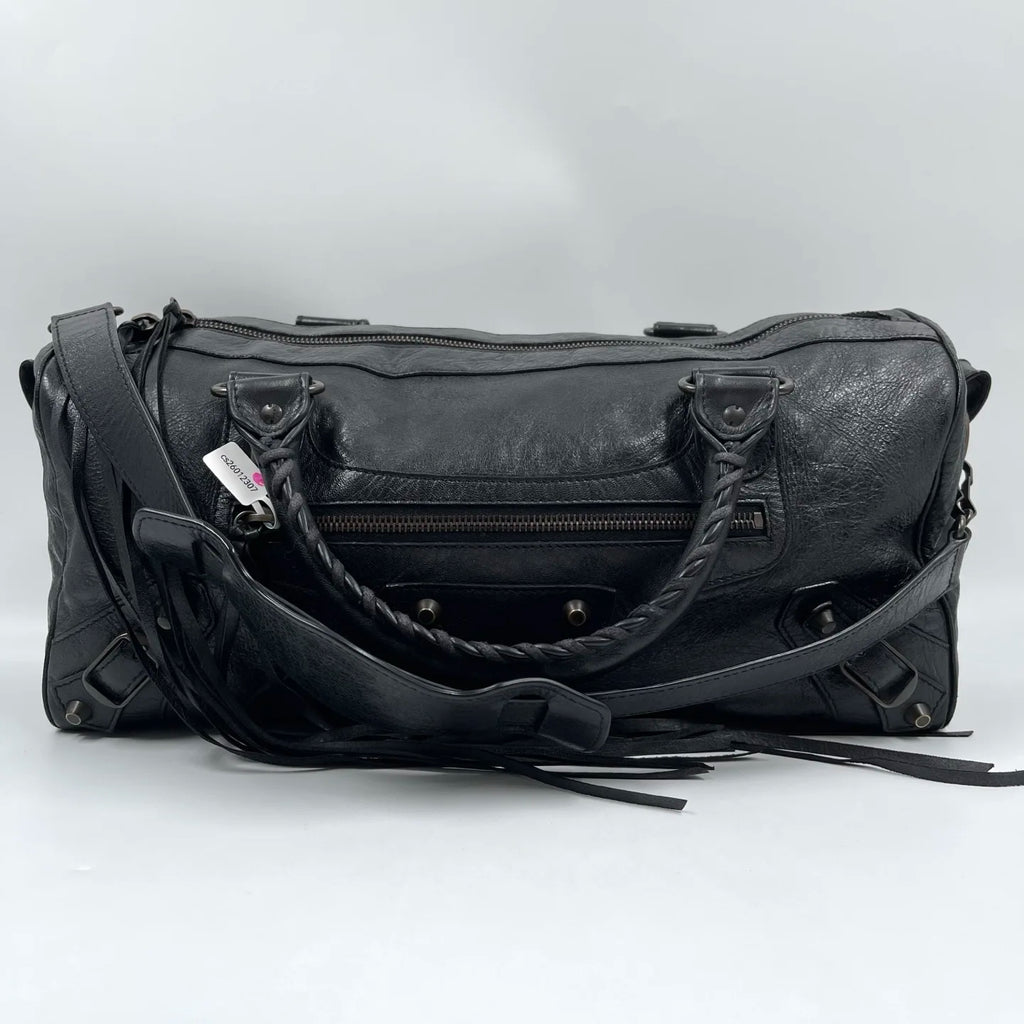 Second-hand black genuine leather designer tote with tassel, braided handles, and unique pillow-shaped silhouette.