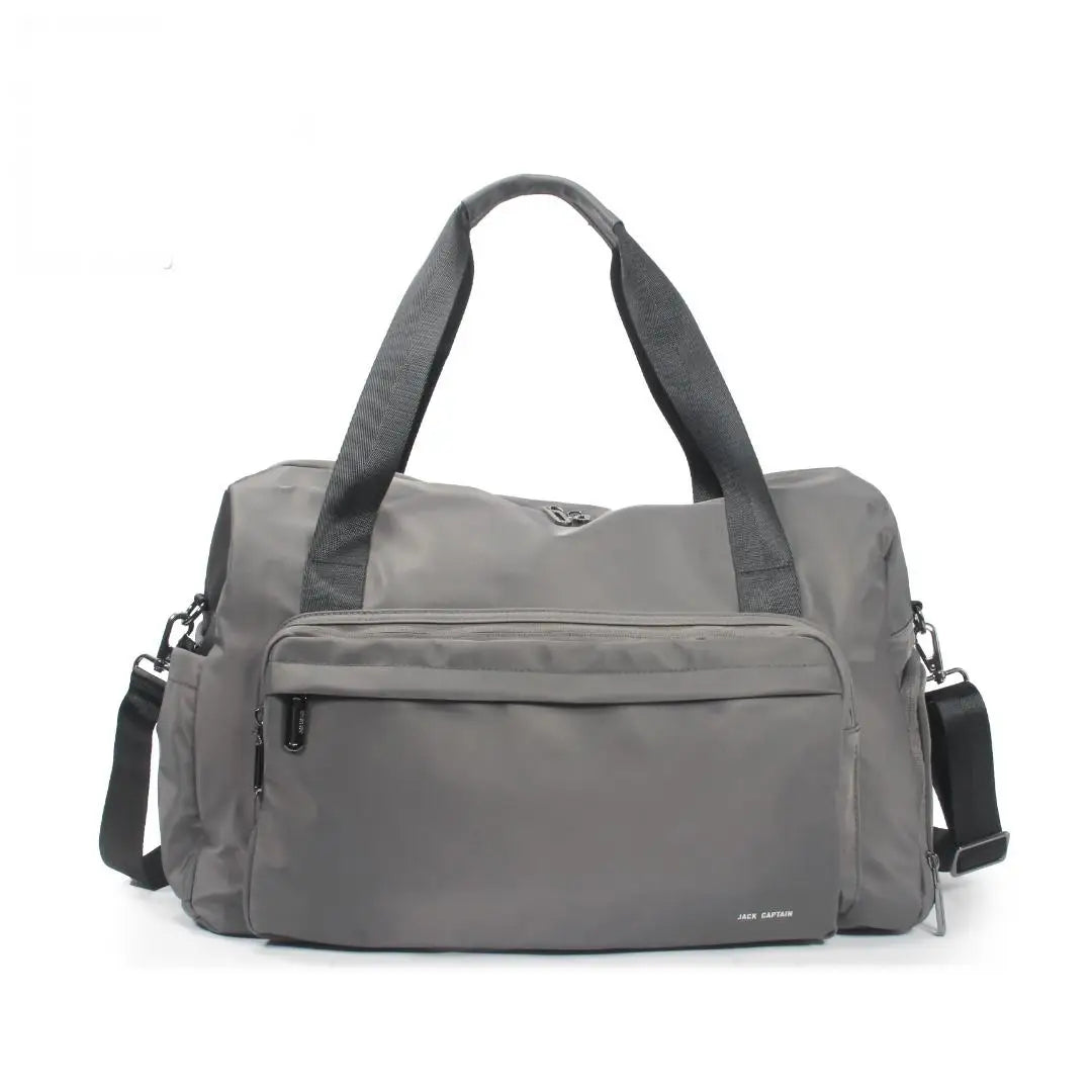 Grey waterproof nylon travel duffel bag with zipper pockets, dual handles, and an adjustable shoulder strap for trips.