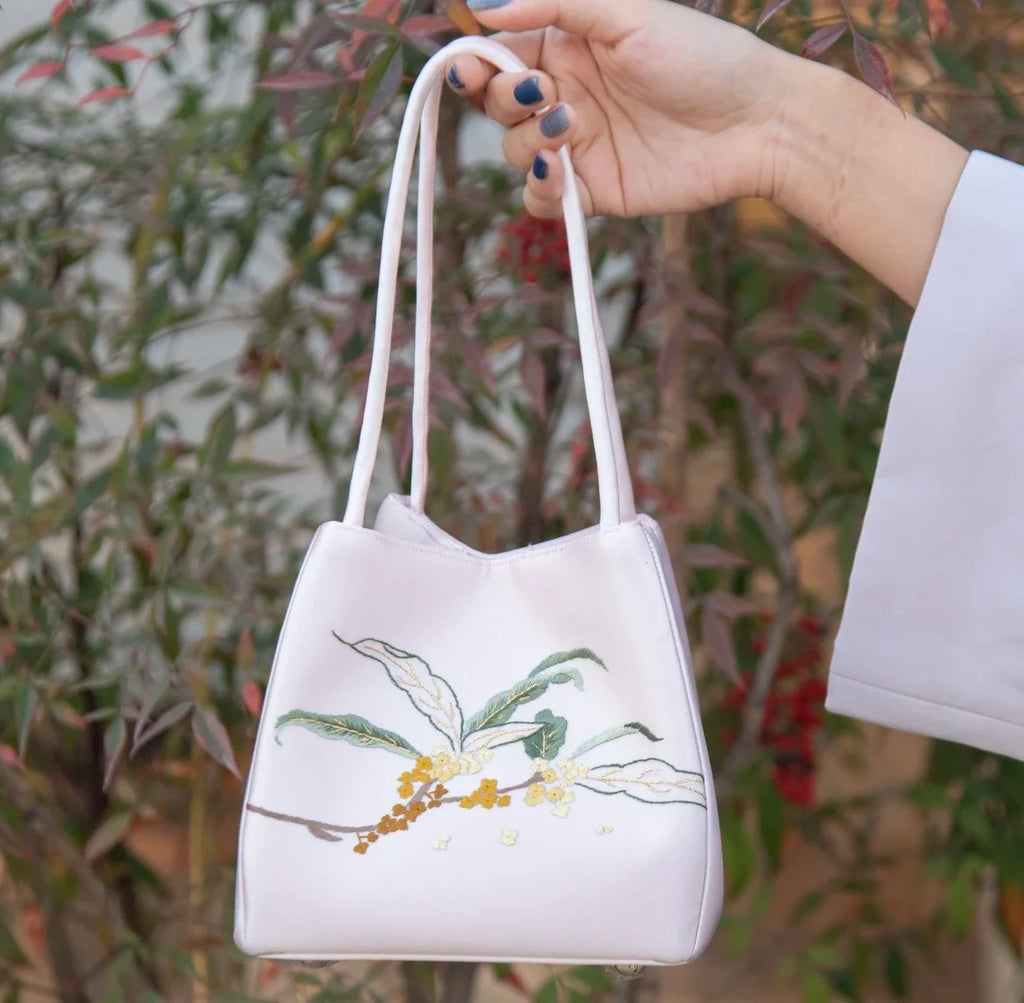 Light pink designer handbag with delicate floral Su embroidery in a classic, daily-use shoulder bag style.