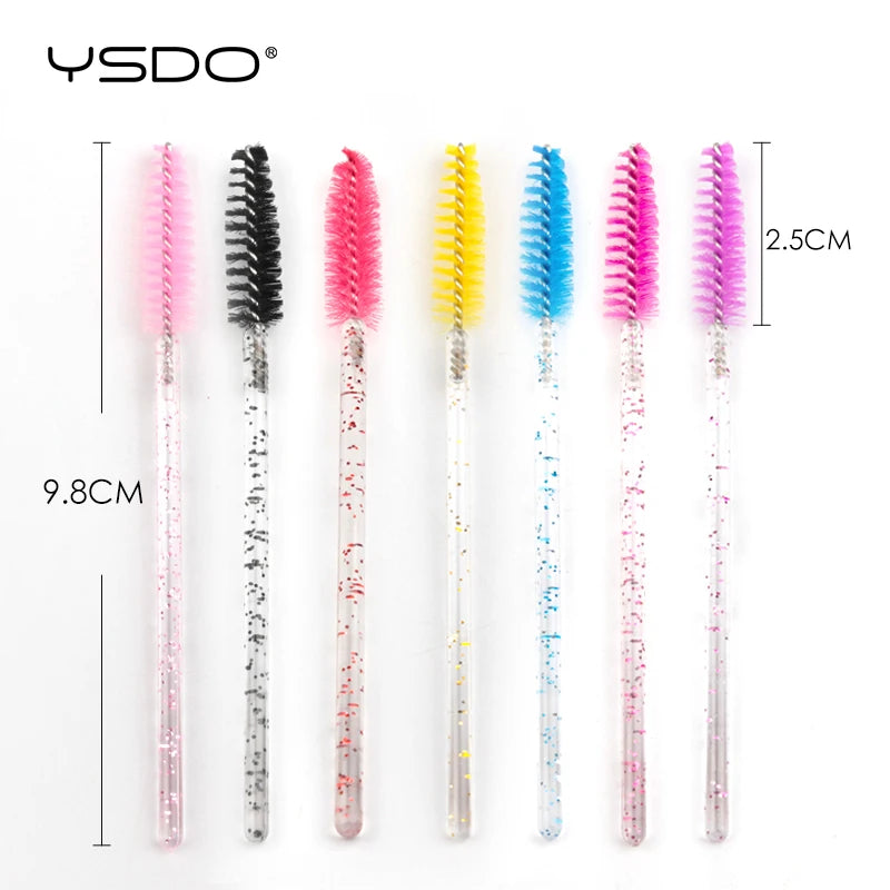 Seven disposable eyelash spoolie brushes with colorful nylon heads and clear, glitter-filled plastic handles.