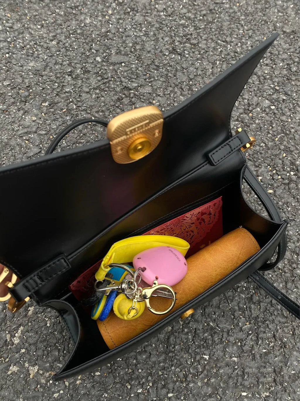 Black designer square underarm handbag with gold magnetic clasp, two-strap design, and spacious PU-lined interior.