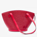 Luxury red leather designer shoulder bag with classic water ripple texture in a trapezoid silhouette.
