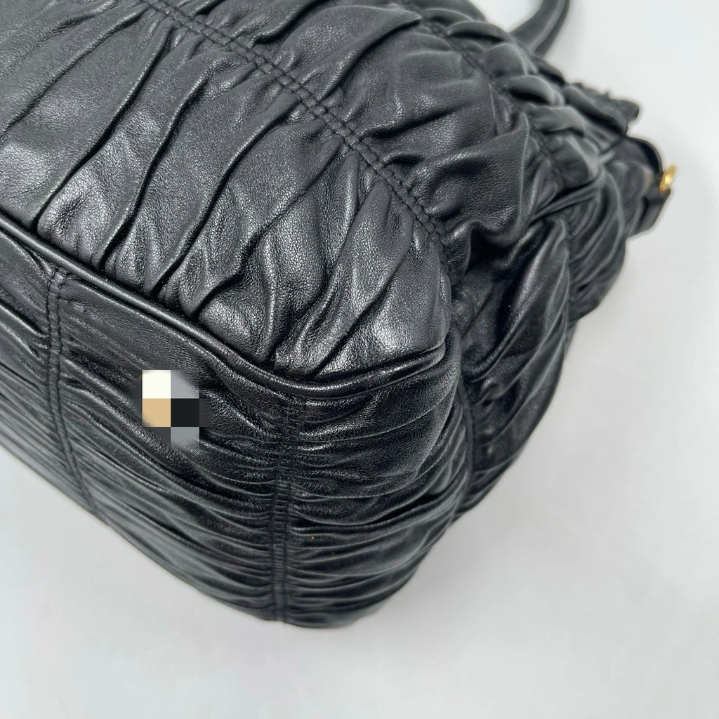 Luxury black pleated leather designer handbag with a classic, elegant retro aesthetic.
