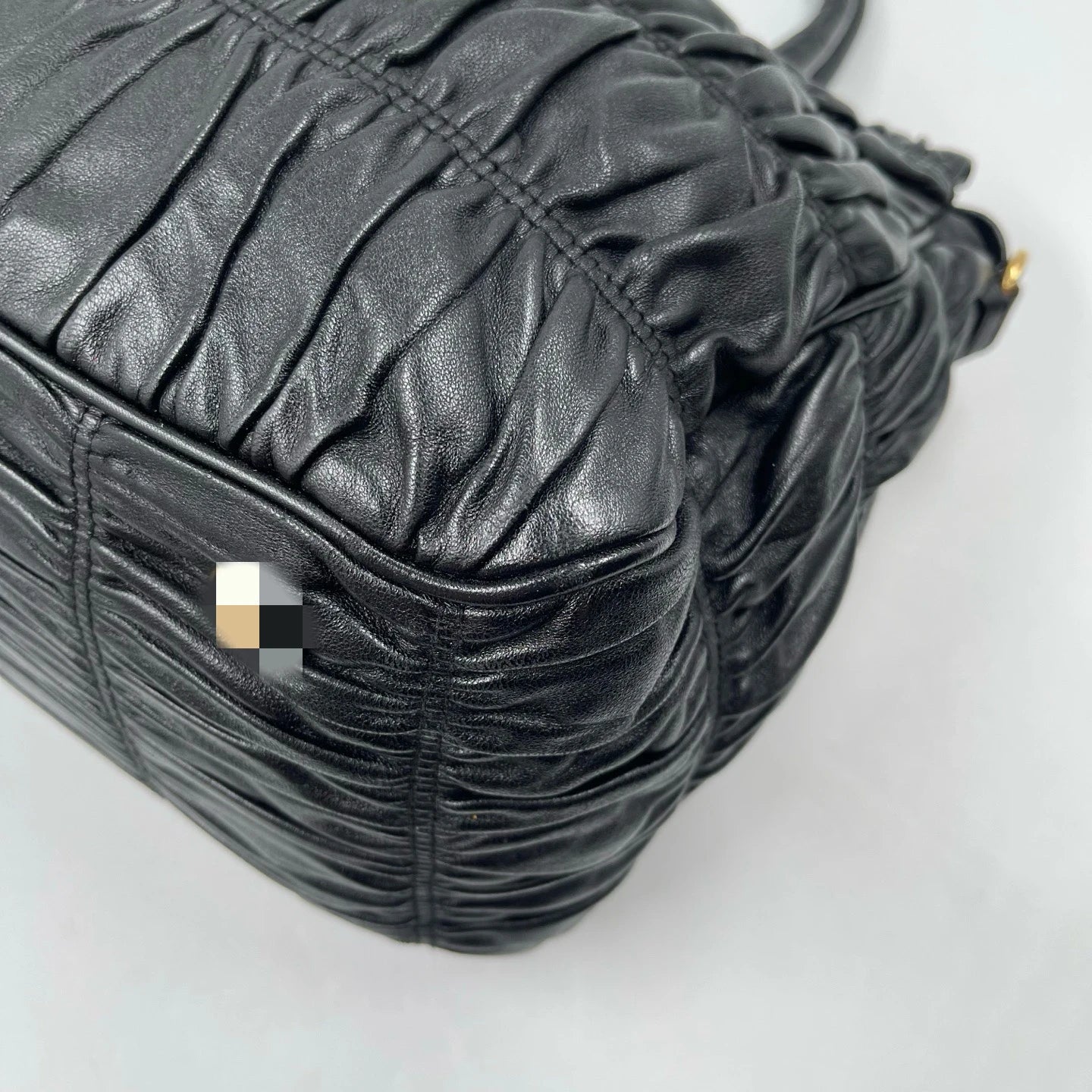 Luxury black pleated leather designer handbag with a classic, elegant retro aesthetic.