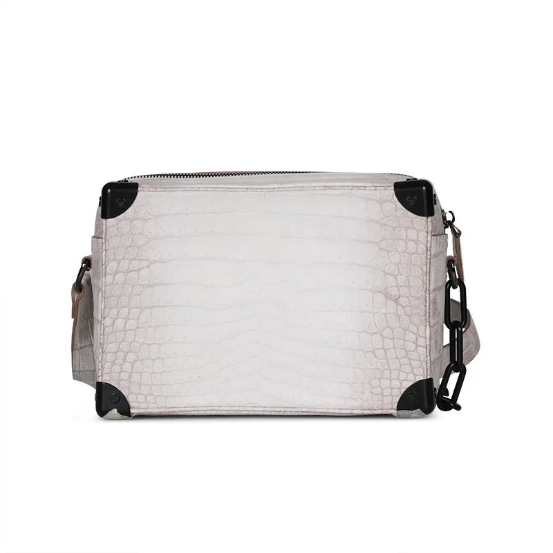 White Himalayan crocodile leather mini trunk handbag with black metal corners and chain strap shoulder detail.