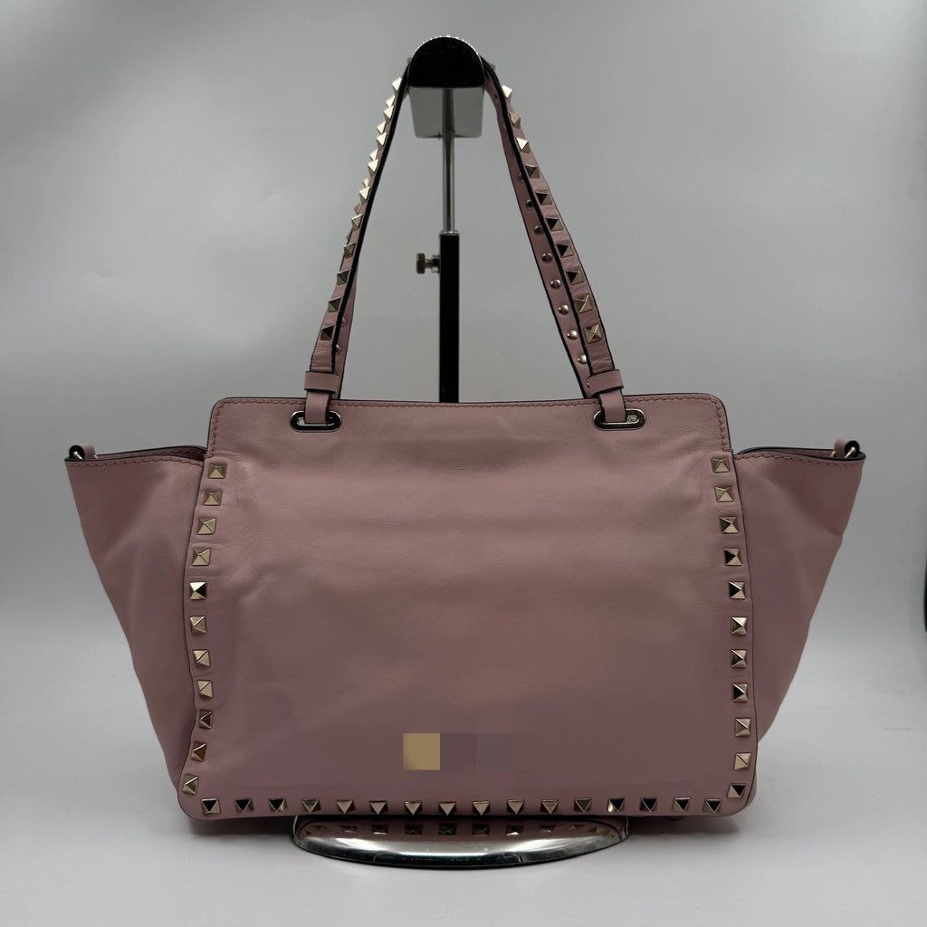 Second-hand pale pink genuine leather designer shoulder bag with gold pyramid rivet trim and dual carry straps.