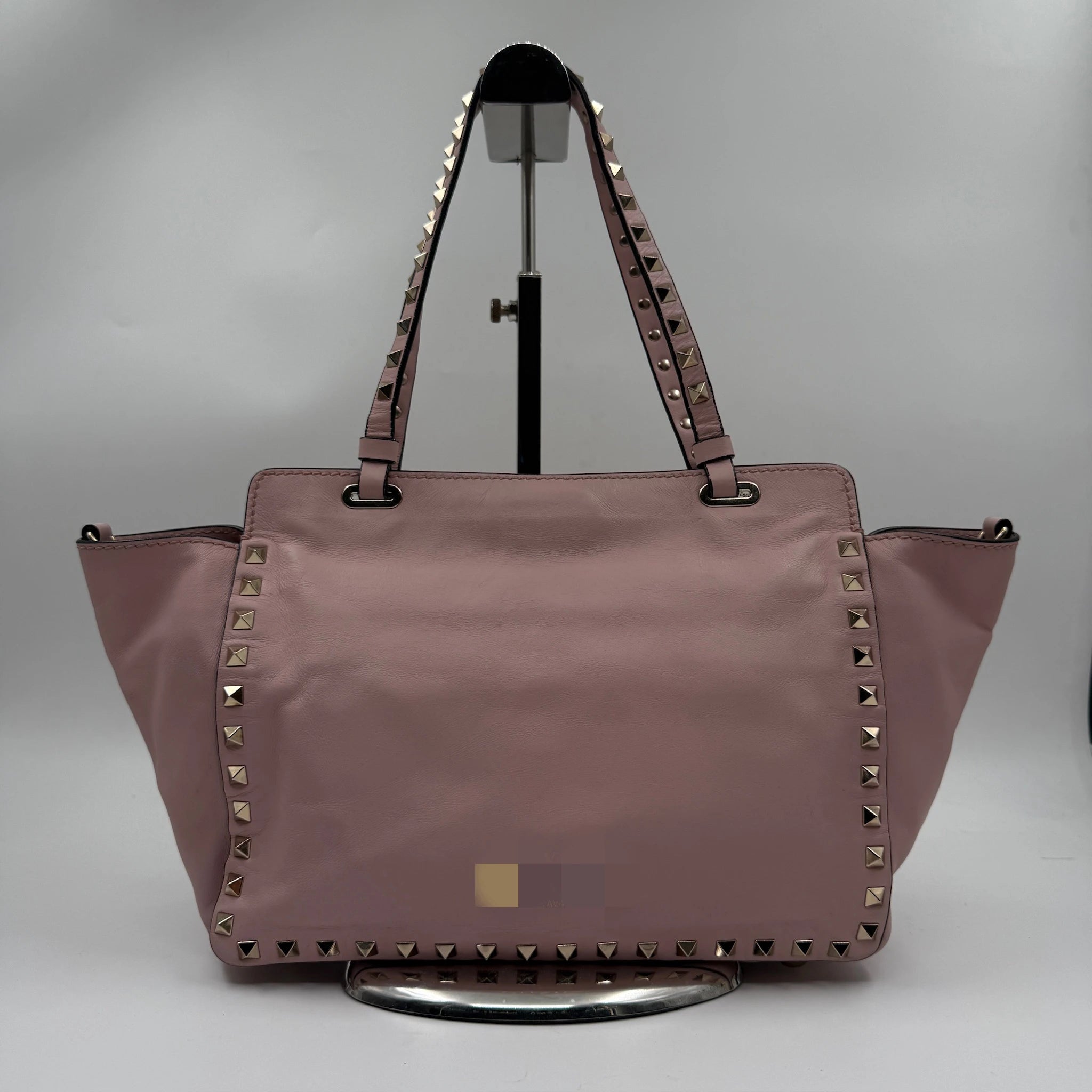 Second-hand pale pink genuine leather designer shoulder bag with gold pyramid rivet trim and dual carry straps.