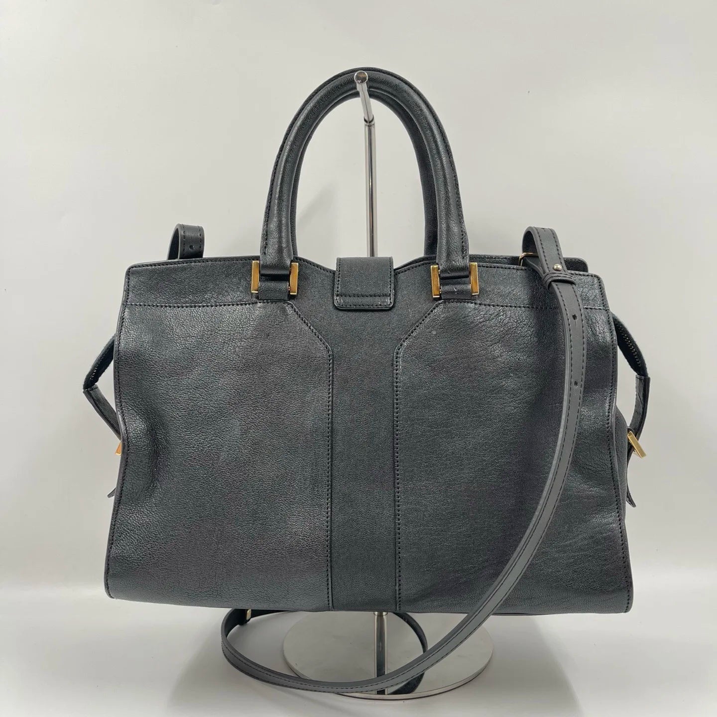 Luxury black genuine leather unisex handbag, pillow shape with dual straps, gold hardware, and retro designer style.