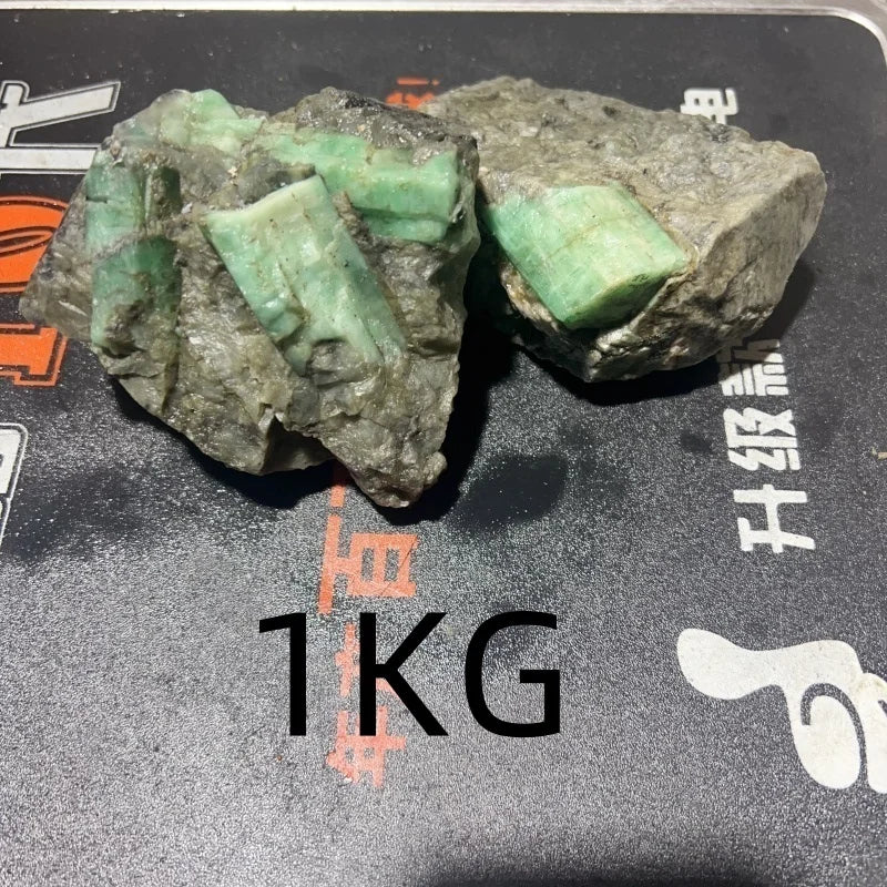 Pair of rough green crystal quartz pieces with mint-green highlights on dark gray rock