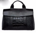 Black genuine leather designer handbag with mixed crocodile-embossed texture, top handle, and flap closure.