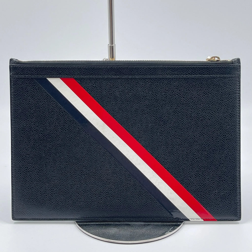 Second-hand black leather designer clutch with red, white, and blue diagonal striped detailing for travel.
